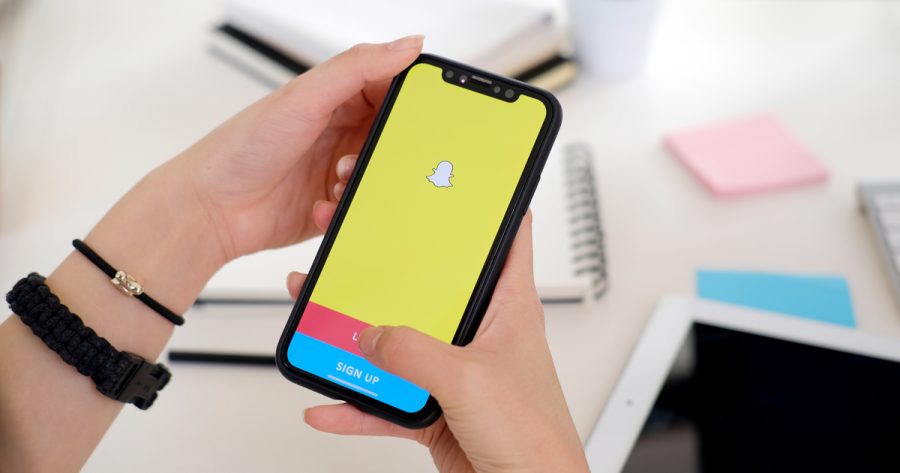 Woman holding a iPhone X with social network service Snapchat on the screen. iPhone X was created and developed by the Apple inc. Snapchat application on iPhone X